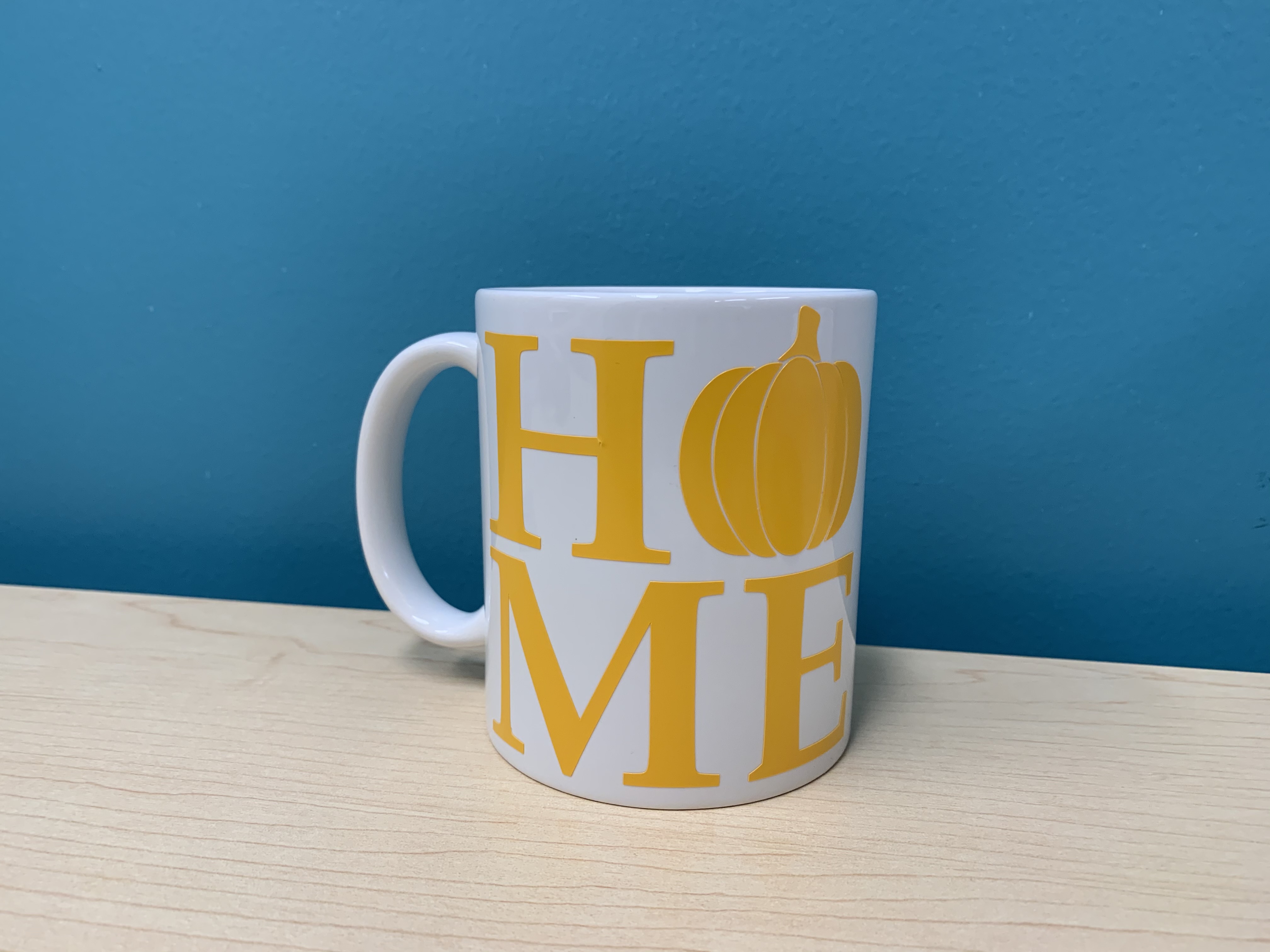 white coffee mug with the word HOME applied to it