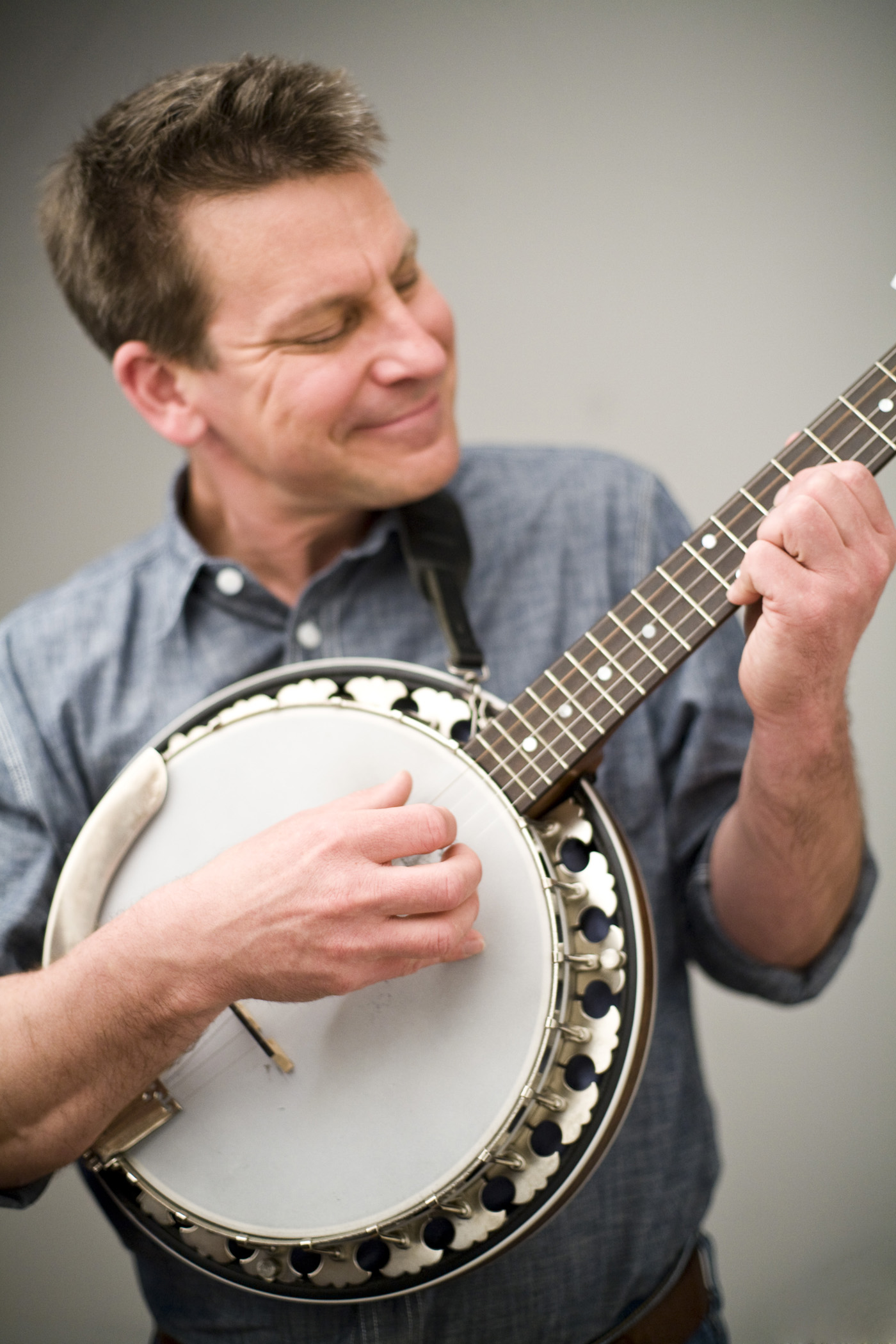 A photo of Jim Gill strumming his banjo