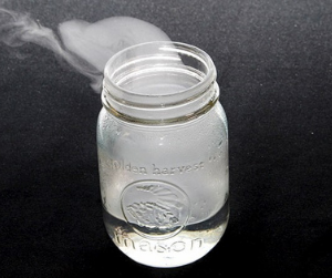 Mason jar filled with clear liquid and vapor escaping the top