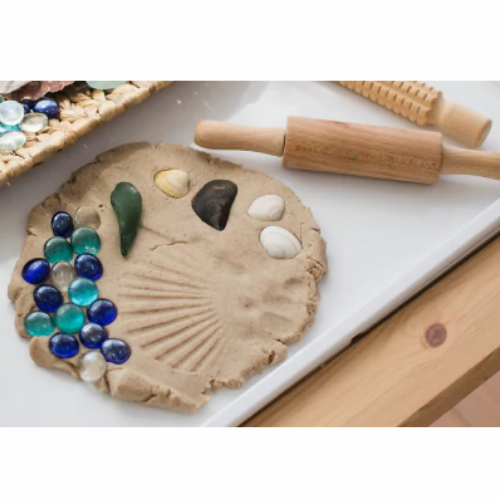 Image of Sand Playdough with a rolling pin and sea glass.