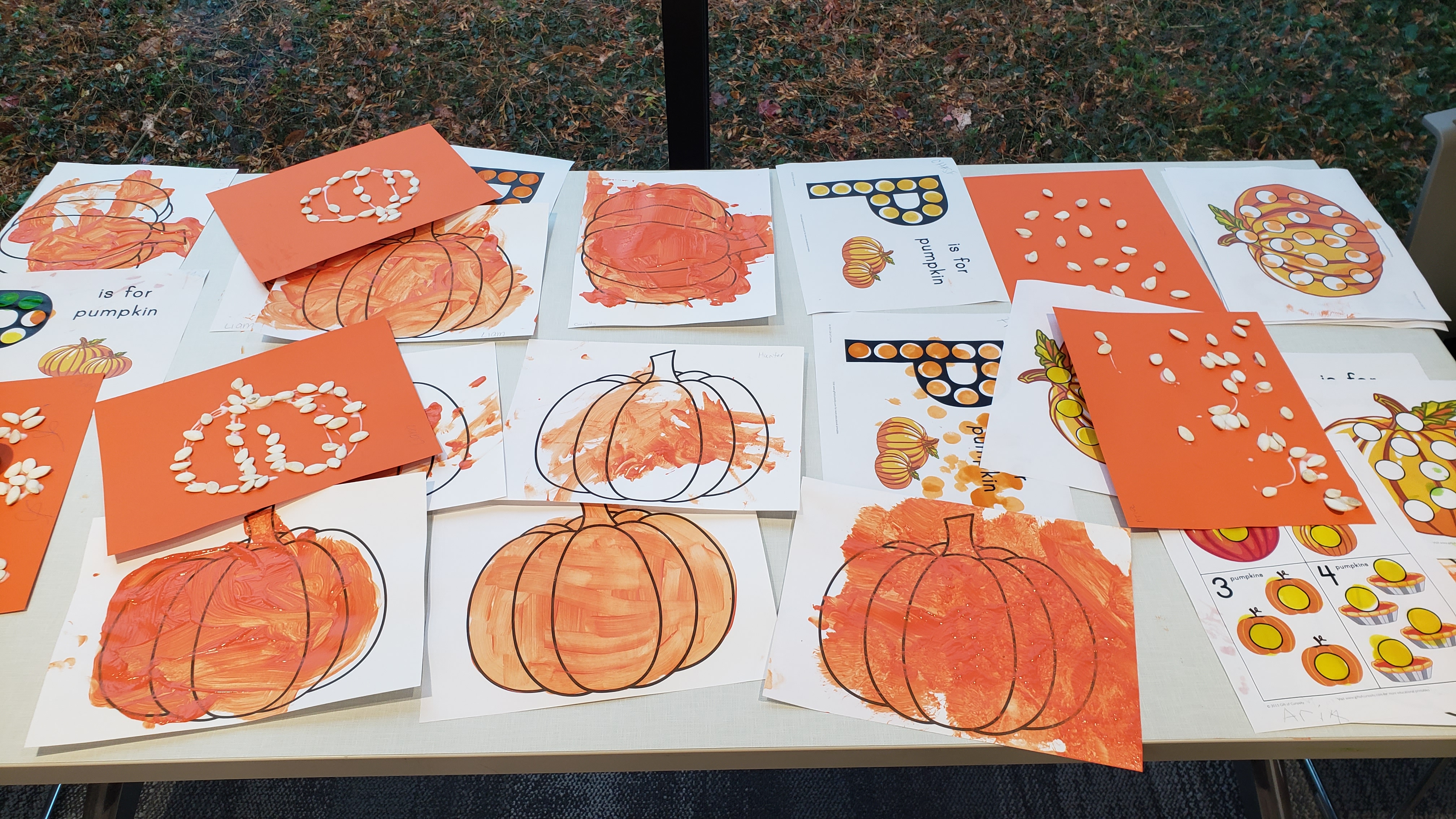 Orange painted pumpkins and pumpkin outlines created with pumpkin seeds.