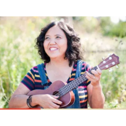 Photo of musician Ann Torralba holding a guitar.