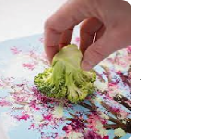 Hand of a child painting with broccoli