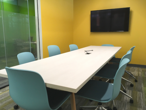 Conference room image with table, chairs, and mounted television