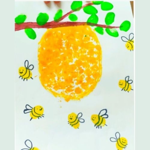 Picture of a painting of a beehive in a tree with fingerprint painted bees