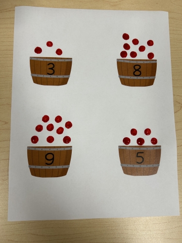 Piece of paper with numbered buckets on it and red dots acting as "apples."