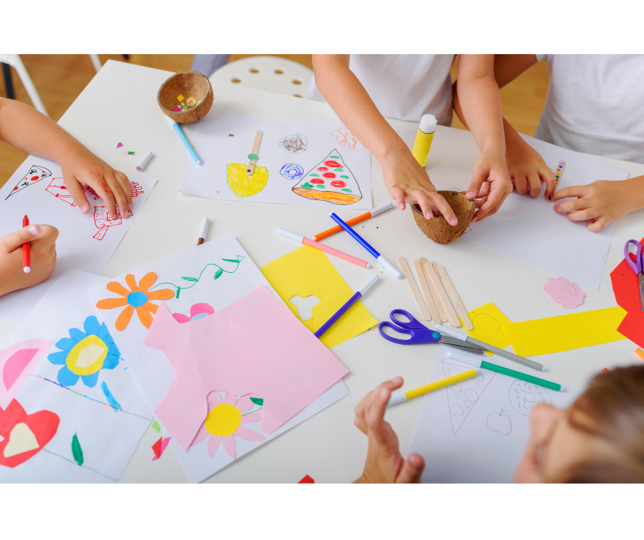 Children's hands working at a craft table.